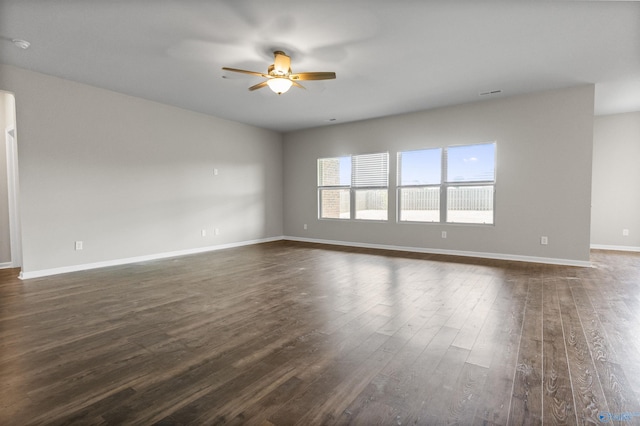 unfurnished room with ceiling fan, baseboards, and dark wood finished floors