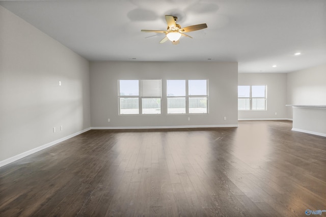 unfurnished living room featuring dark wood-type flooring, recessed lighting, a ceiling fan, and baseboards