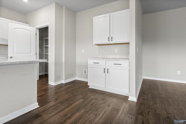 kitchen featuring white cabinetry, light countertops, baseboards, and dark wood-style flooring