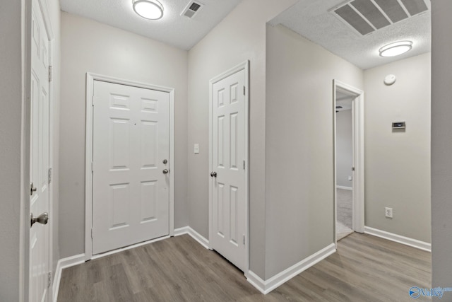 hall featuring a textured ceiling and hardwood / wood-style floors