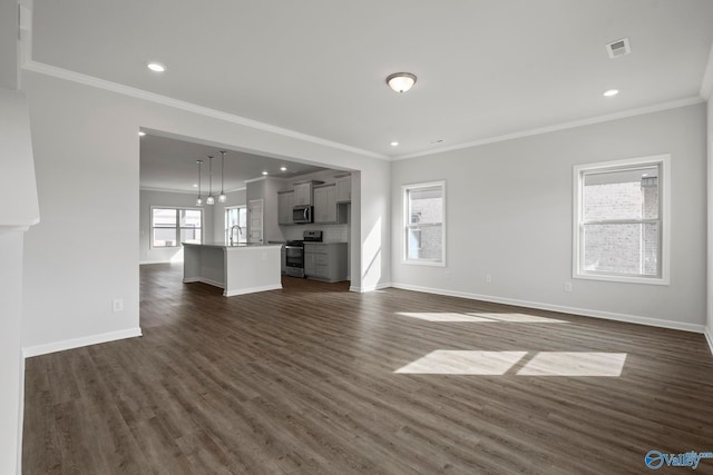 unfurnished living room featuring recessed lighting, dark wood-type flooring, a sink, baseboards, and ornamental molding