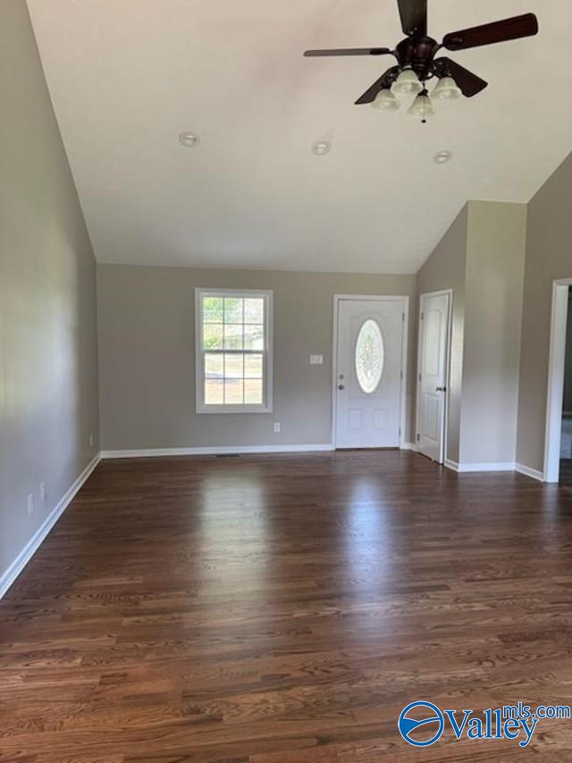 unfurnished living room featuring lofted ceiling, hardwood / wood-style floors, and ceiling fan