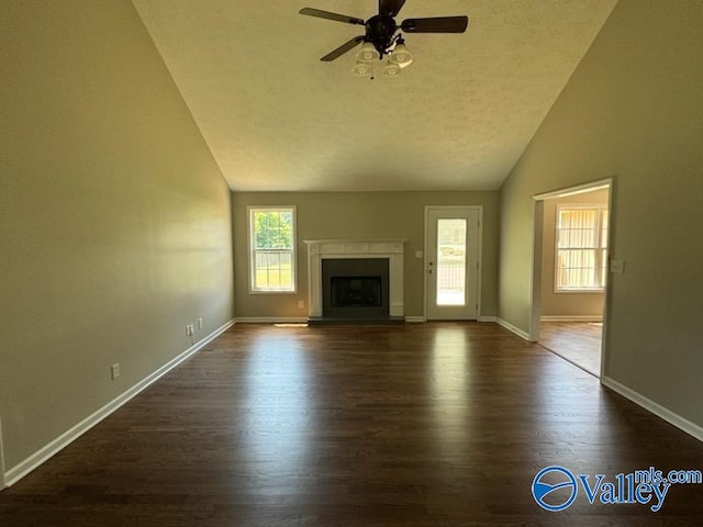 unfurnished living room with ceiling fan, high vaulted ceiling, and dark wood-type flooring