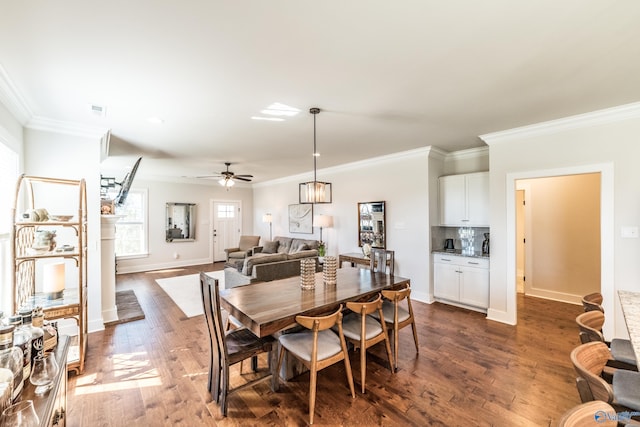 dining space with ceiling fan, dark hardwood / wood-style flooring, and ornamental molding