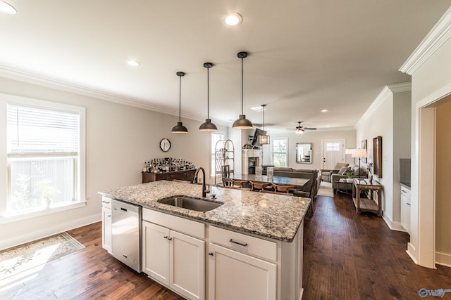 kitchen with a kitchen island with sink, white cabinets, stainless steel dishwasher, ceiling fan, and light stone counters