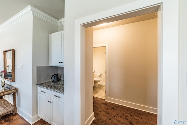 hall with dark hardwood / wood-style floors and ornamental molding