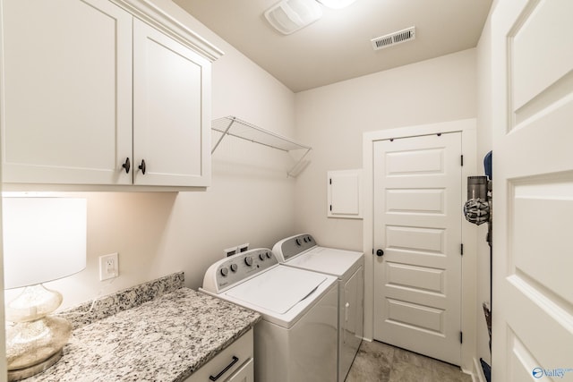 laundry area featuring washer and dryer and cabinets