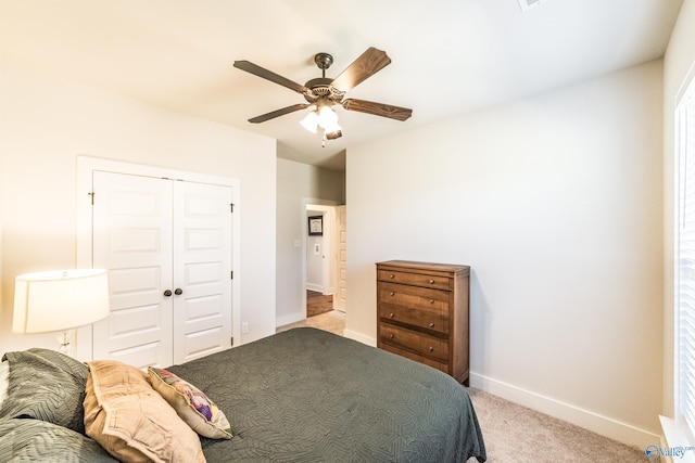 carpeted bedroom featuring ceiling fan and a closet