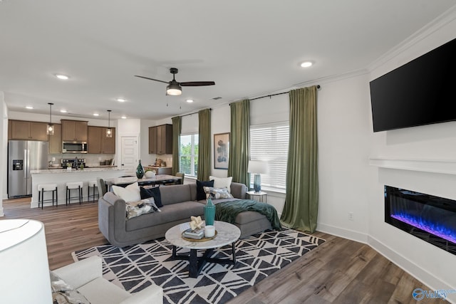 living room featuring ornamental molding, dark hardwood / wood-style floors, and ceiling fan