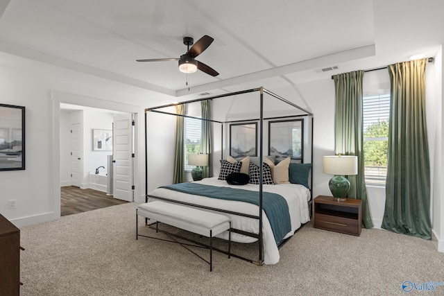 carpeted bedroom with ceiling fan and ensuite bath