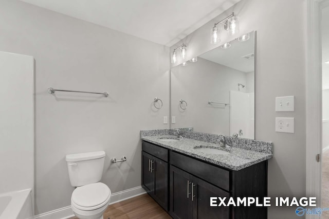 full bathroom with vanity, hardwood / wood-style flooring, toilet, and shower / washtub combination