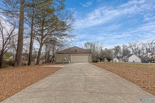 view of home's exterior featuring an attached garage, roof with shingles, and driveway