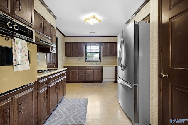 708 Apache St NW, Hartselle, AL 35640 - kitchen featuring white appliances, wallpapered walls, light flooring, light countertops, and dark brown cabinets