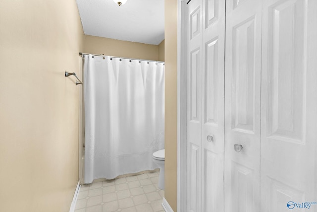 708 Apache St NW, Hartselle, AL 35640 - bathroom with a closet, tile patterned floors, toilet, curtained shower, and baseboards