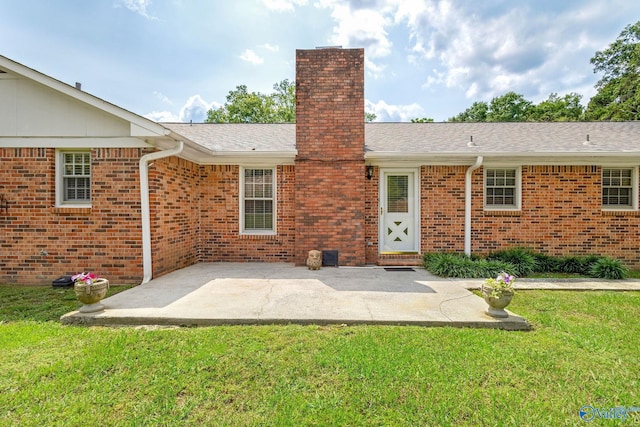 708 Apache St NW, Hartselle, AL 35640 - rear view of house with a chimney, a yard, brick siding, a patio area, and a shingled roof