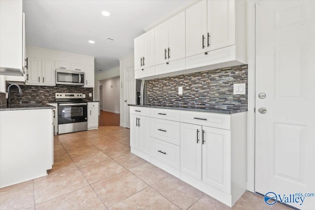 304 Ohara Dr, Albertville, AL 35950 - kitchen featuring stainless steel appliances, backsplash, light tile patterned flooring, white cabinets, and recessed lighting