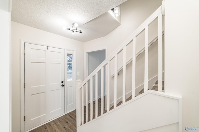 entryway featuring a textured ceiling and dark hardwood / wood-style flooring