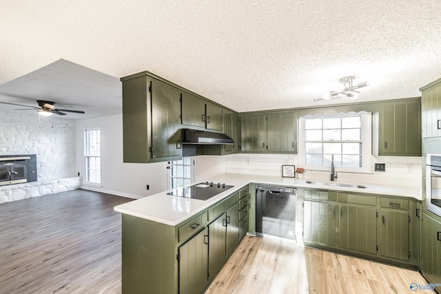 kitchen with sink, black appliances, a textured ceiling, and light wood-type flooring