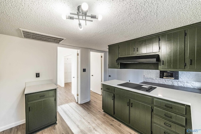 kitchen featuring black electric cooktop, light hardwood / wood-style flooring, and green cabinetry