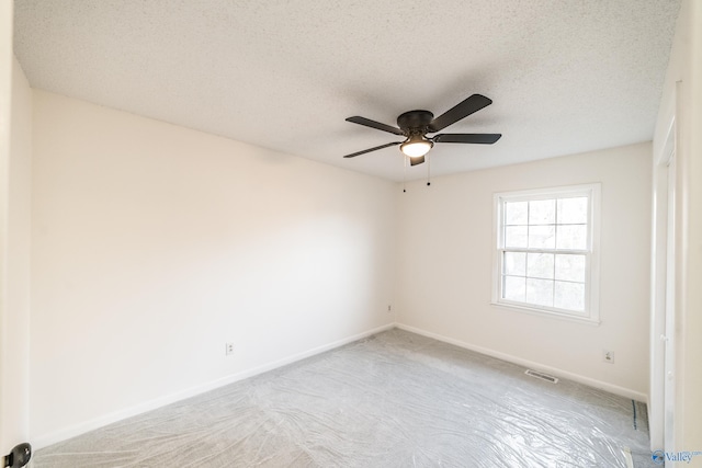 carpeted empty room featuring ceiling fan and a textured ceiling