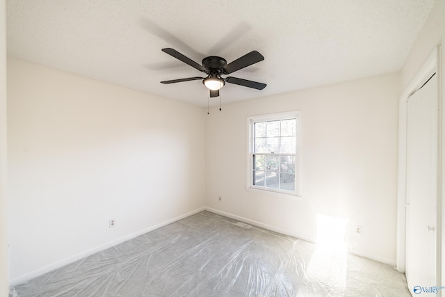 spare room featuring a textured ceiling and ceiling fan