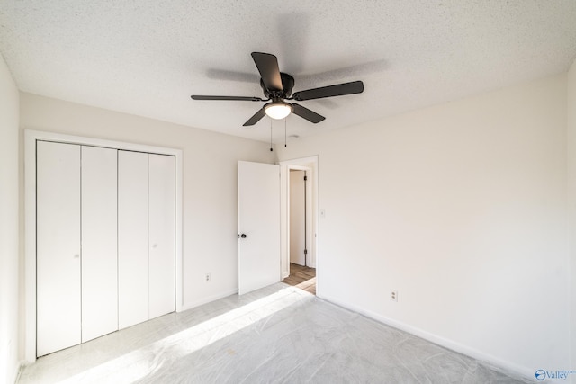 unfurnished bedroom featuring a textured ceiling, a closet, and ceiling fan