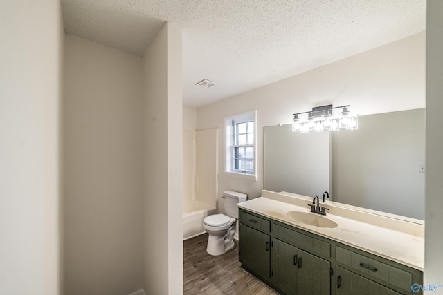 full bathroom with bathtub / shower combination, vanity, a textured ceiling, wood-type flooring, and toilet