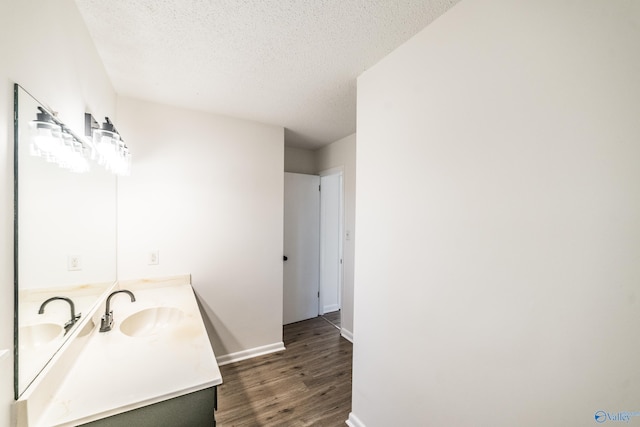 bathroom featuring hardwood / wood-style floors, vanity, and a textured ceiling