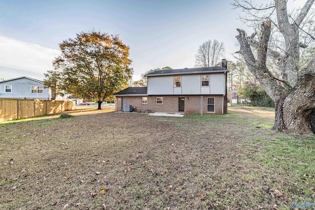 back of property with a yard, cooling unit, and a patio area