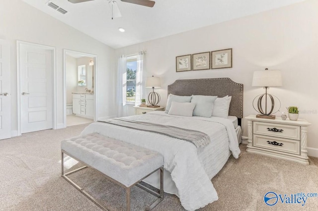 carpeted bedroom featuring ceiling fan, ensuite bathroom, and lofted ceiling