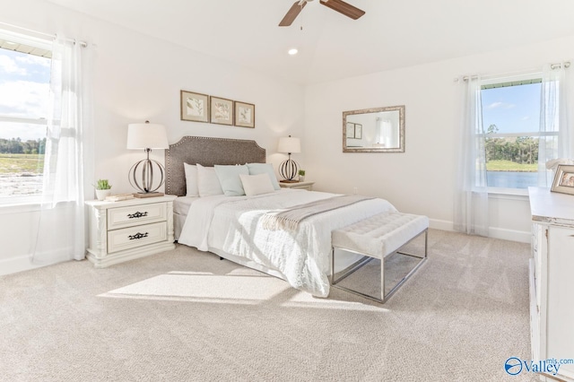 carpeted bedroom featuring ceiling fan and multiple windows