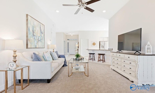 living room featuring ceiling fan, light colored carpet, and vaulted ceiling