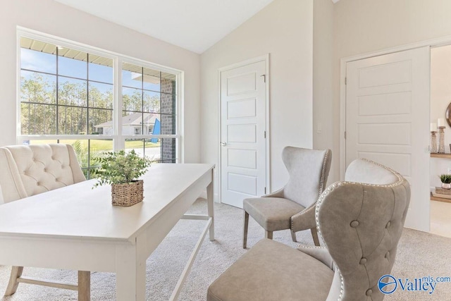 office space featuring vaulted ceiling and light carpet