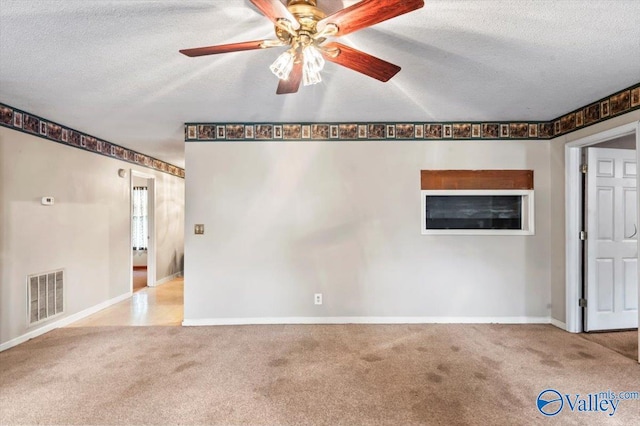 carpeted empty room featuring ceiling fan and a textured ceiling