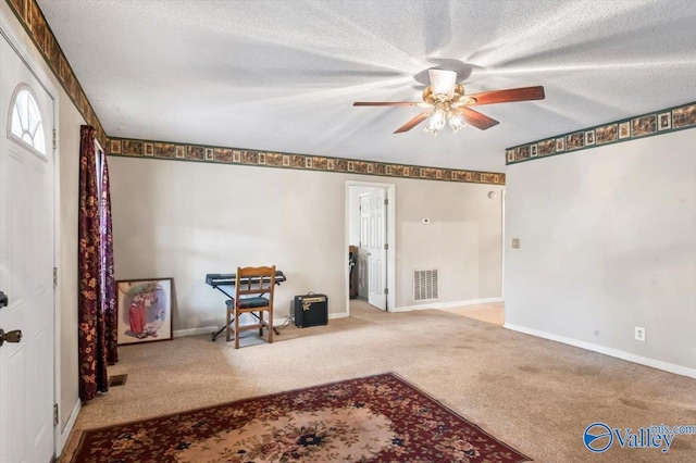 interior space with ceiling fan and a textured ceiling