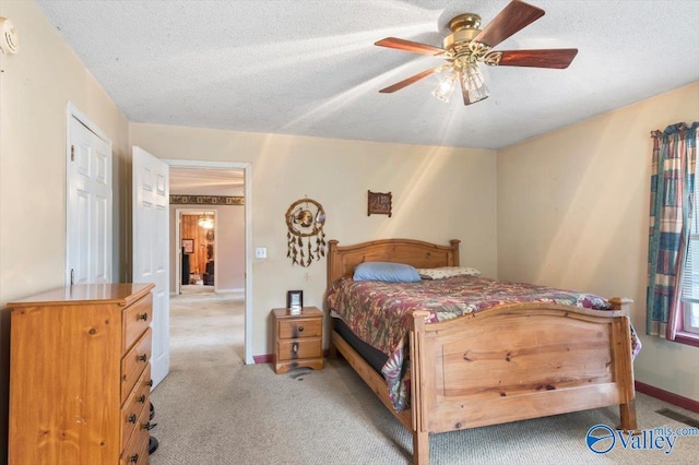 carpeted bedroom with ceiling fan and a textured ceiling