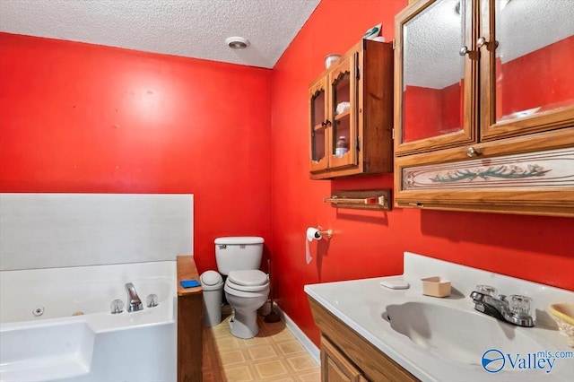 bathroom with vanity, toilet, a tub, and a textured ceiling