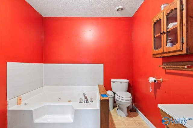 bathroom with a bath, a textured ceiling, and toilet