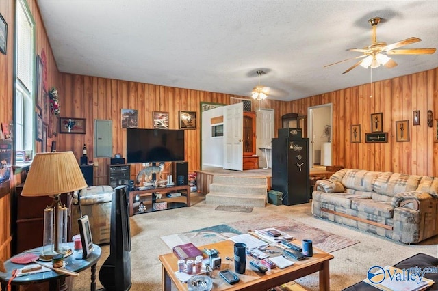 living room with wooden walls, a textured ceiling, and carpet flooring