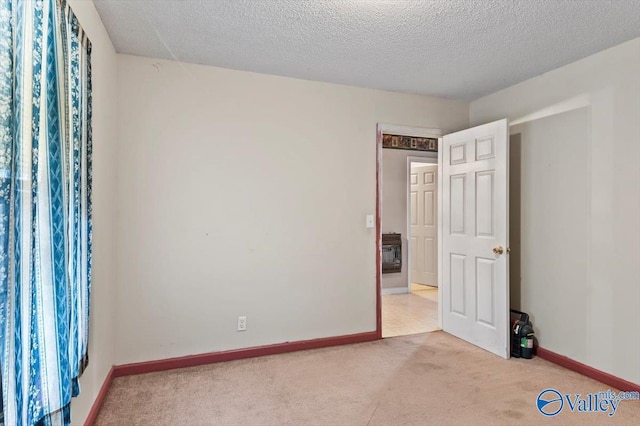 carpeted empty room featuring a textured ceiling