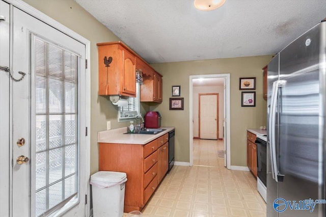 kitchen featuring a healthy amount of sunlight, sink, white electric range oven, and stainless steel refrigerator