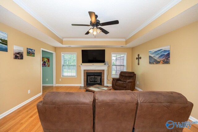 27586 Phillip Wagnon Dr, Athens, AL 35613 - living area with a raised ceiling, crown molding, light wood finished floors, ceiling fan, and a tiled fireplace
