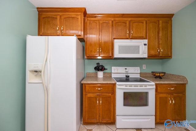 27586 Phillip Wagnon Dr, Athens, AL 35613 - kitchen with white appliances, light tile patterned floors, and brown cabinets