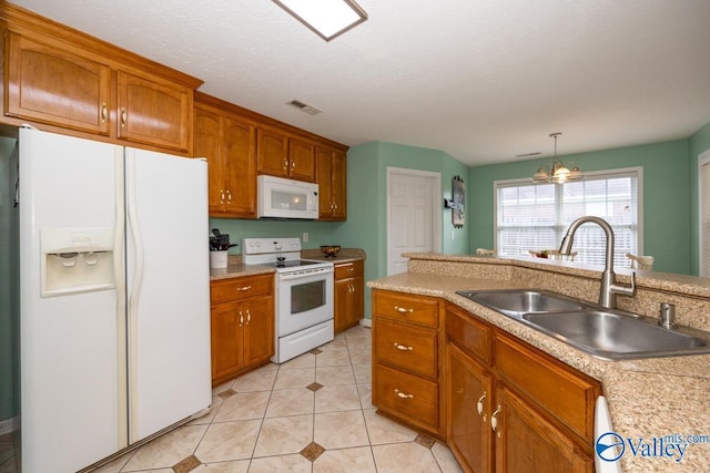 27586 Phillip Wagnon Dr, Athens, AL 35613 - kitchen featuring white appliances, a sink, brown cabinetry, light countertops, and light tile patterned floors