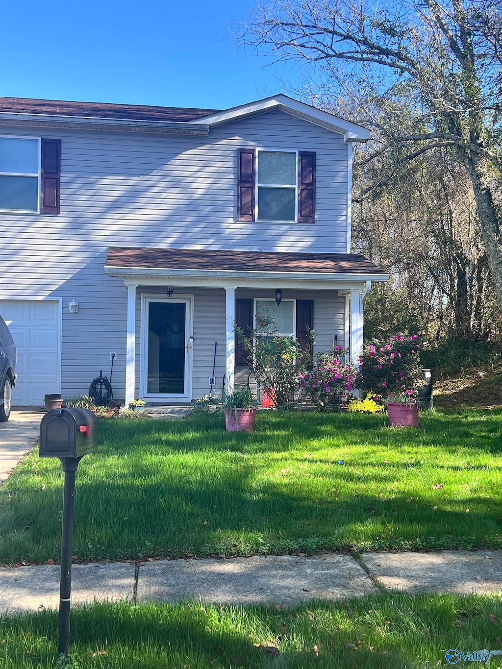 view of front of property with a porch, a garage, and a front yard