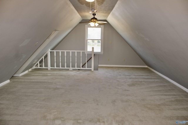 additional living space featuring vaulted ceiling, ceiling fan, and light colored carpet