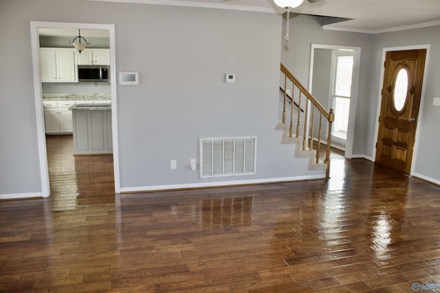 unfurnished living room with dark hardwood / wood-style flooring and crown molding