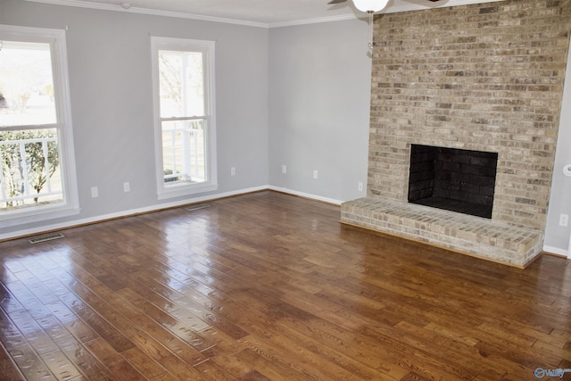 unfurnished living room featuring dark wood-type flooring, a wealth of natural light, and ornamental molding