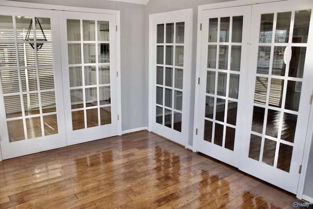 entryway with french doors, an inviting chandelier, and hardwood / wood-style flooring