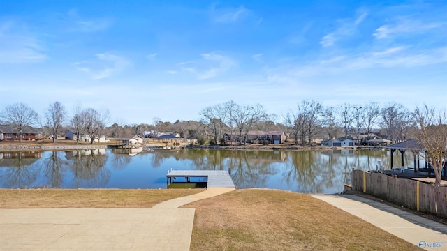 view of dock with a water view and a lawn